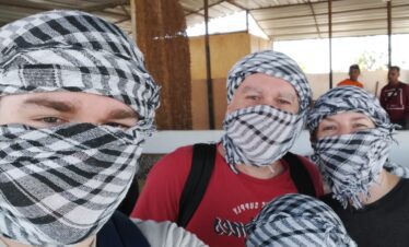 Une famille de quatre personnes, parents et enfants, portant tous des keffiyehs, avant de partir en safari dans le désert.