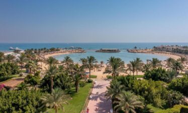 Vue panoramique sur l'allée, les jardins luxuriants et la plage privée de l'hôtel 5 étoiles.