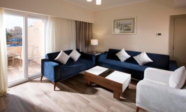 Salon élégant d’une suite avec terrasse et vue sur la piscine.