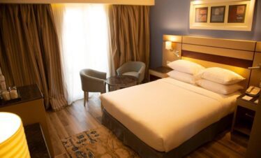 Chambre avec lit double, table et chaises, accès terrasse.