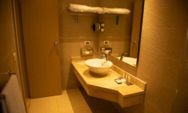 Salle de bain élégante avec lavabo en marbre et accessoires pratiques.