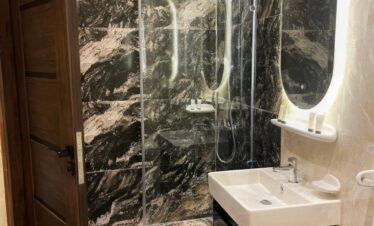 Une salle de bain moderne et élégante, avec douche à l'italienne et touches marbrées.