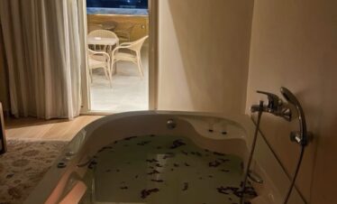 Jacuzzi avec pétales de roses, vue imprenable sur les pyramides depuis la terrasse.