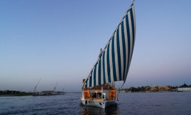 Un bateau Dahabiya sur le Nil au début de soirée, illuminé par une lumière douce.