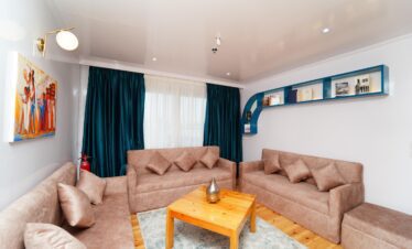 Espace de détente chic avec des assises confortables, une table centrale élégante et une décoration sobre, idéal pour se relaxer à bord d’un bateau de croisière sur le Nil.