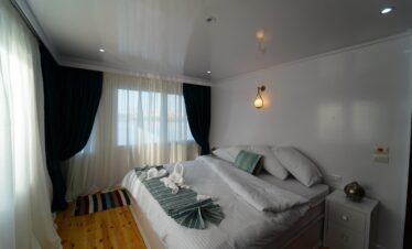 Chambre lumineuse et élégante avec lit double dans un bateau Dahabiya en Égypte.