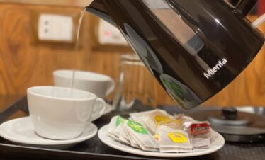 Détail du plateau de bienvenue avec bouilloire, tasses à café et sachets de thé, pour un moment de détente.