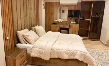 Vue apaisante d'une chambre élégante avec un lit en velours marron et un décor en bois chaleureux.